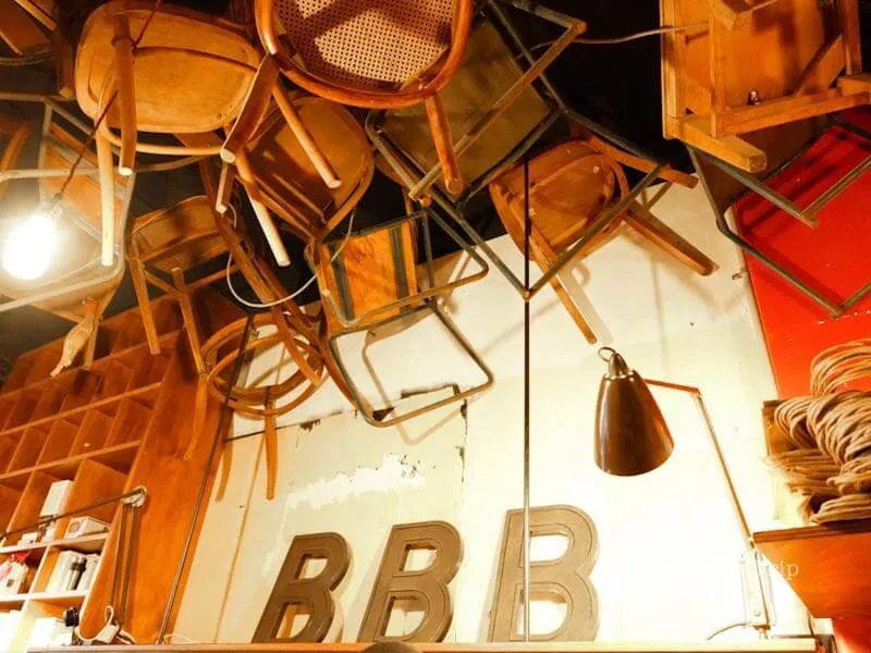 BBBのネオンと吊り下げチェアが並ぶ個性的なインテリア