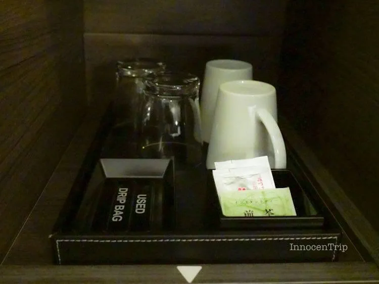 マグカップと粉末茶が並ぶ客室のティーセット