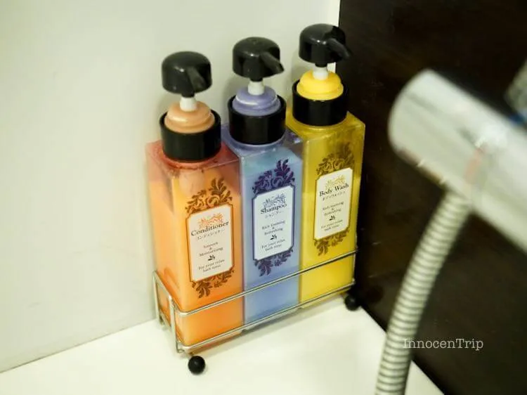 バスタブのコーナーに置かれたシャンプーとボディソープディスペンサー