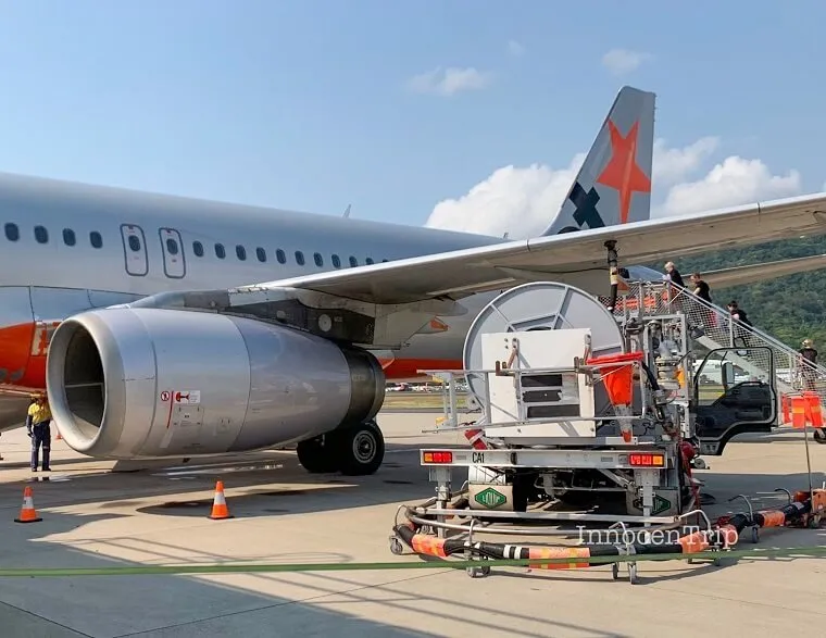 ジェットスター機後方ドアへ続くタラップを上る乗客