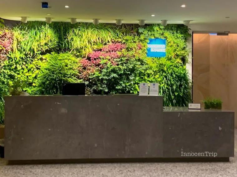 メルボルン空港アメックスラウンジ入口の受付カウンターとブルーのロゴサイン