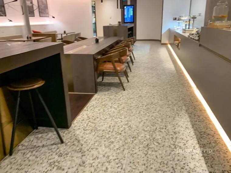 American Express Loungeメルボルンのカフェ風ビュッフェ通路とテーブル席
