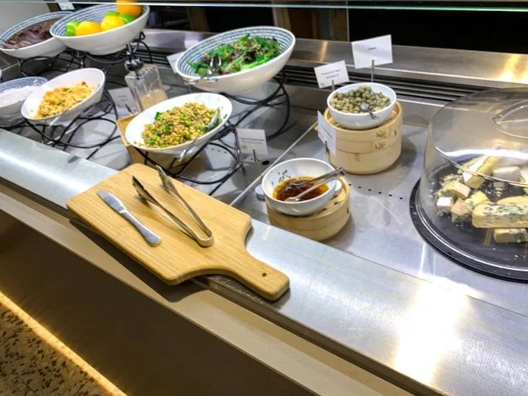American Express Loungeメルボルンのビュッフェに並ぶサラダとチーズの軽食