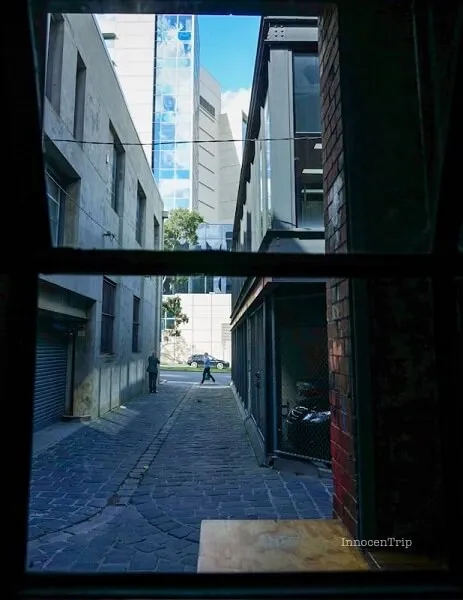 裏手に続く小道と光が差し込む通路