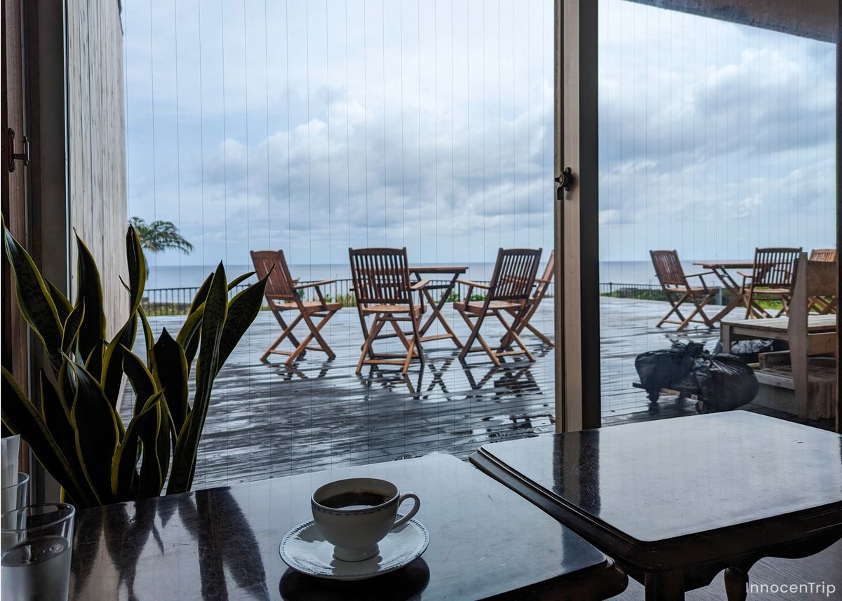 大きな窓越しに海を望む静かなカフェの店内