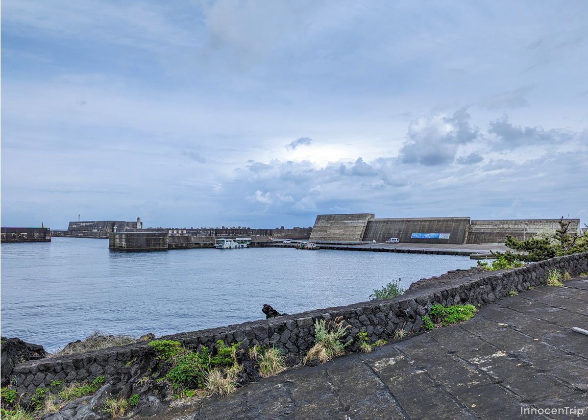 雨上がりの港町で濡れた道路と停泊する船が並ぶ景色