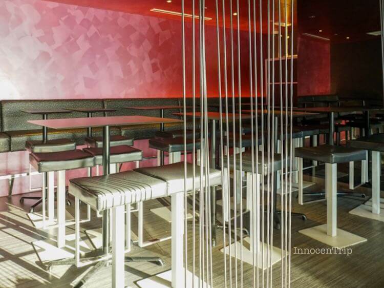 赤い壁とカウンターテーブルが並ぶラウンジスペース