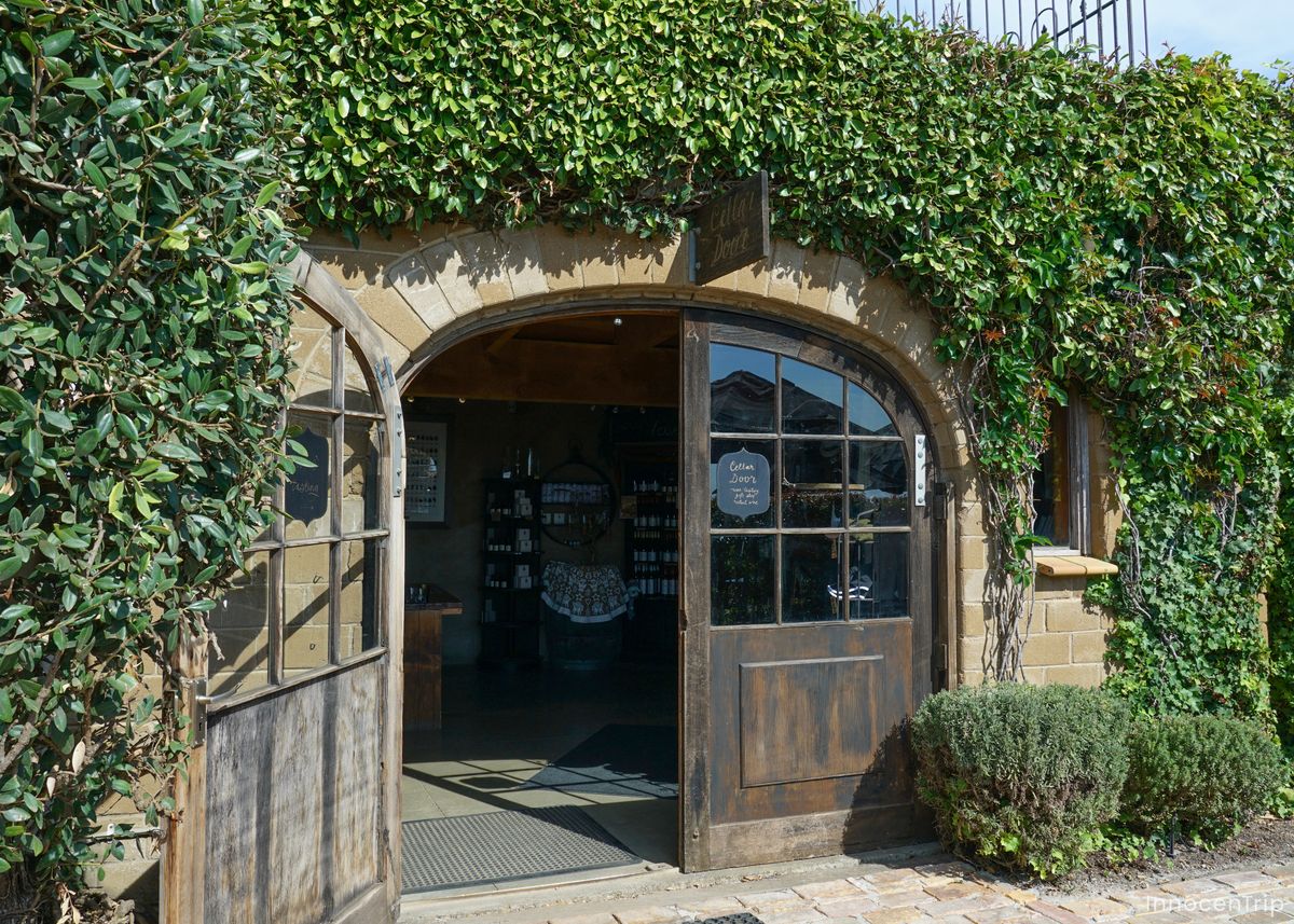 緑に覆われた石造りのワイナリーの入口